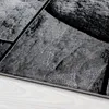 A close-up view of a modern gray rug with a geometric pattern, placed on a light wooden floor. Anteprima dell’immagine prodotto