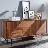 A wooden sideboard with decorative carvings, displayed in a room setting with framed art and decorative objects. Náhled obrázku produktu