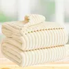 Two folded blankets stacked on a wooden surface with a blurred background. Podgląd zdjęcia produktu