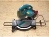A miter saw is placed on a wooden surface. Podgląd zdjęcia produktu