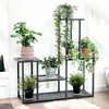 A multi-tiered metal plant stand filled with various potted plants, placed indoors against a white wall. Podgląd zdjęcia produktu