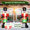 Two inflatable nutcracker soldiers are displayed in front of a brick building with green doors and Christmas wreaths. Produktbild-Vorschau