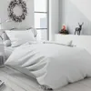 A bedroom scene with a bed dressed in white bedding, decorated for Christmas. Náhled obrázku produktu