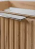 Close-up of a modern wooden cabinet with a fluted design and a silver handle. Anteprima dell’immagine prodotto
