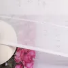 A close-up of a white hat and pink roses, partially covered by a sheer white fabric with text. Produktbild-Vorschau