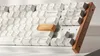 A close-up shot of a white mechanical keyboard with a wooden side panel. Produktbild-Vorschau