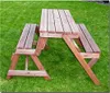 A wooden picnic table with attached benches sits on a green lawn. Produktbild-Vorschau