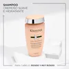 A bottle of Kérastase Curl Manifesto shampoo is displayed on a minimalist white and light gray background, with geometric blocks. Produktbild-Vorschau