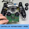 A disassembled game controller with a circuit board being held by a hand. Produktbild-Vorschau
