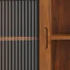 A close-up view of a wooden cabinet with a corrugated metal sliding door. Produktbild-Vorschau