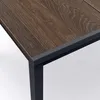 Close-up of the corner of a wooden table with a black metal frame. Produktbild-Vorschau