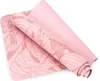 A pink yoga mat with a leaf pattern is partially rolled up. Podgląd zdjęcia produktu