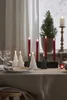 A table setting with Christmas-themed candles and a small Christmas tree. Produktbild-Vorschau