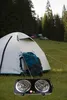 A camping scene with a tent and backpack, with an electric stove in the foreground. Náhľad obrázku produktu