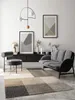 A modern living room with a sofa, chair, rug, and artwork. Produktbild-Vorschau