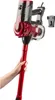 A hand holding a red and black cordless vacuum cleaner. Produktbild-Vorschau