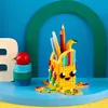 A LEGO DOTS pencil holder shaped like an octopus, filled with pens and pencils, on a blue surface. Podgląd zdjęcia produktu