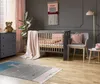 A nursery room with a crib, dresser, chair, and rug. Náhled obrázku produktu