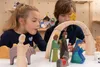Two children are playing with a wooden nativity scene. Produktbild-Vorschau