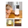 A young boy looking at a small LED lamp on a wooden table, with other shots of the lamp on a shelf and on stairs. Voir les images du produit