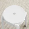 A white stool on a textured rug. Voir les images du produit