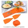 A top-down view of a mandolin slicer and its attachments, with prepared salads and shredded carrots in the background. Anteprima dell’immagine prodotto