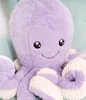 A close-up shot of a purple plush octopus toy with cream-colored accents on its tentacles, resting on a light blue surface. Náhľad obrázku produktu