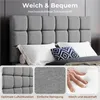 A bed with a gray upholstered headboard and pillows, with close-up shots of the fabric and a hand pressing into foam. Produktbild-Vorschau