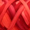 A close-up view of thick, braided yarn in various shades of red, orange, and pink. Produktbild-Vorschau