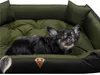 A small dog is lying on a green and black dog bed. Podgląd zdjęcia produktu