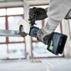 A person wearing gloves is using a cordless angle grinder to cut a metal beam. Sparks are flying from the cutting action. Produktbild-Vorschau