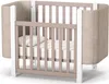 A baby crib with a mattress and pillow inside, shown from a slightly elevated side angle against a white background. Produktbild-Vorschau