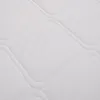 A close-up view of a white quilted mattress. Produktbild-Vorschau