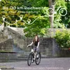 A young woman rides an electric bike on a paved path next to stone stairs and trees. Voir les images du produit