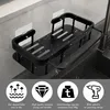 A black kitchen sink caddy with water droplets on it, placed next to a sink. Below the product are four circular icons with text describing its features. Produktbild-Vorschau