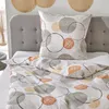 A close-up view of bedding with a circular pattern, including a pillow and duvet cover, on a bed. Produktbild-Vorschau