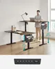 A person standing and working at a height-adjustable desk. Produktbild-Vorschau