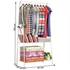A white metal garment rack with clothes and folded items on shelves. Náhled obrázku produktu