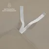 A close-up view of a taupe-colored fabric with white ribbons attached to a corner, suggesting a bedding product. Produktbild-Vorschau