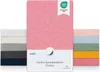 A display of multiple colored fitted sheets, with a main pink sheet prominently featured and a stack of other colored sheets to the left and right. Produktbild-Vorschau