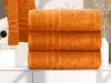 Three stacked orange towels on a white counter next to a sink. Anteprima dell’immagine prodotto