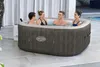 Four people are relaxing in a hot tub outdoors. Produktbild-Vorschau