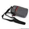 A gray pouch with a red zipper and a black strap is shown against a white background. Produktbild-Vorschau