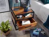 A nightstand with a drawer open, next to a bed and a plant. Podgląd zdjęcia produktu