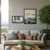 A digital wall clock and weather station is mounted on a wall above a sofa in a modern living room or patio area. Produktbild-Vorschau