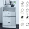 A white chest of drawers with three drawers and an open shelf, displayed next to decorative items. The right side of the image contains marketing icons and text describing product features. Produktbild-Vorschau
