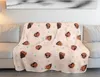 A patterned blanket is draped over a sofa in a living room setting. Produktbild-Vorschau