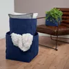 Two dark blue woven storage baskets are shown, one stacked on top of the other, with blankets inside. A brown leather chair with a green plant in a dark blue basket is in the background. Podgląd zdjęcia produktu