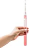 A hand holding a test tube filled with pink liquid and a hydrometer inside. Produktbild-Vorschau