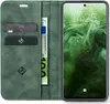 A green flip case for a smartphone, open to reveal card slots and a euro banknote, with the smartphone screen displaying the time and date. Produktbild-Vorschau